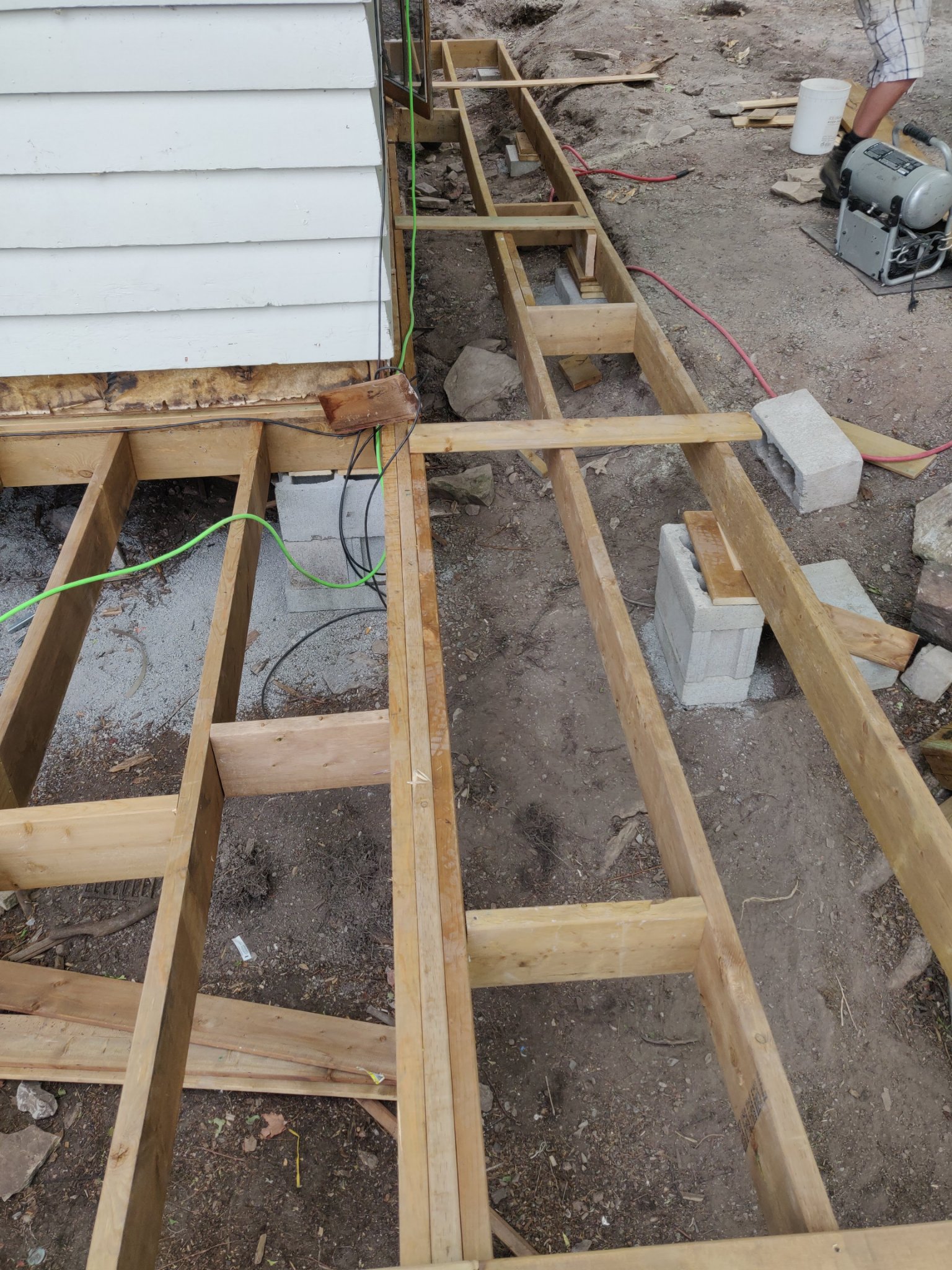 Wrap-around deck joists and blocking on concrete block piers around a house corner